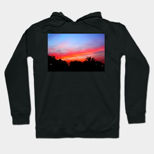 Stunning red purple sunset over a coastal town Hoodie